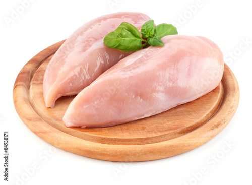 Raw chicken fillets on wooden board isolated on white