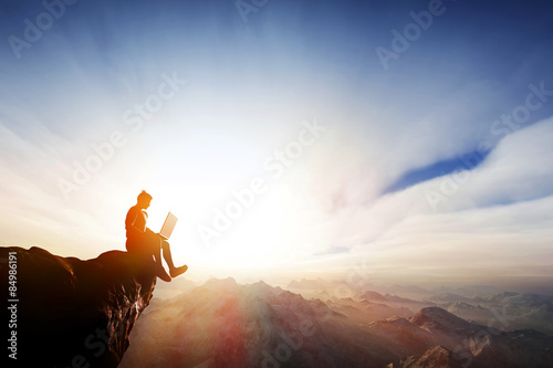 Man working on notebook on top of the mountains. Internet freedom