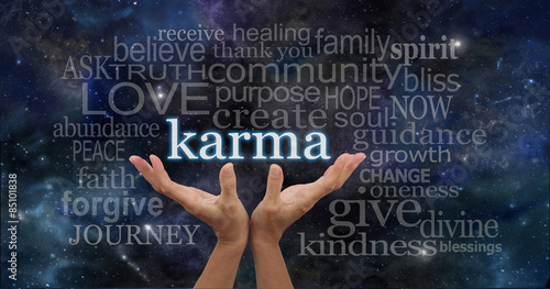 Cosmic Karma - Female hands cupped upwards with the word 'Karma' floating away surrounded by a relevant word cloud on a deep space night sky dark blue background 