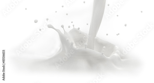 Pouring milk splash, close-up view, isolated on white background.