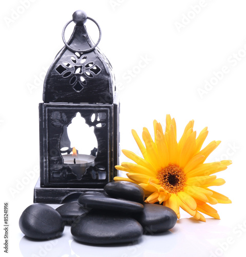 Lantern and black stones on a white background