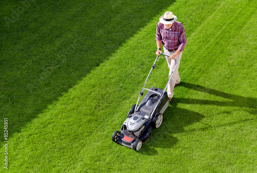 Mowing senior man in the garden