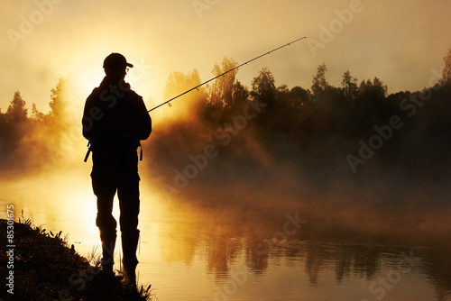 fisher fishing on foggy sunrise