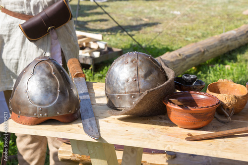two ancient helmet and sword on wooden table