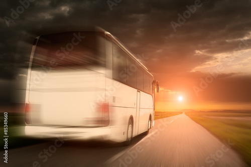 White bus in speed driving on an empty asphalt road