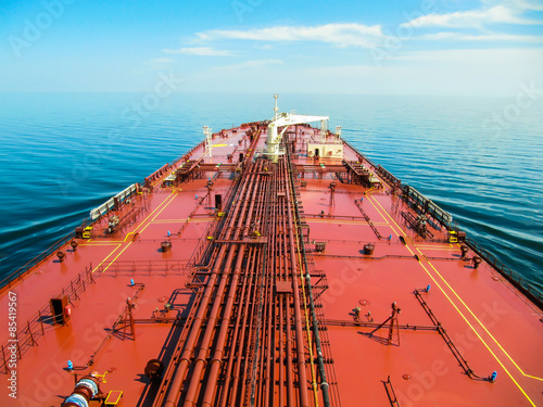 Oil tanker is proceeding in blue ocean under cloudy sky - stock photo