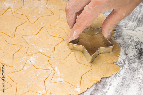 Making gingerbread christmas cookies with metal cutter. Ginger dough and flour