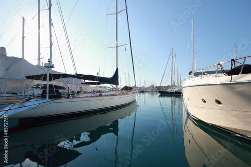 reflections of super yachts and motor power boats in a marina 