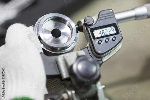 operator inspection automotive part by micrometer