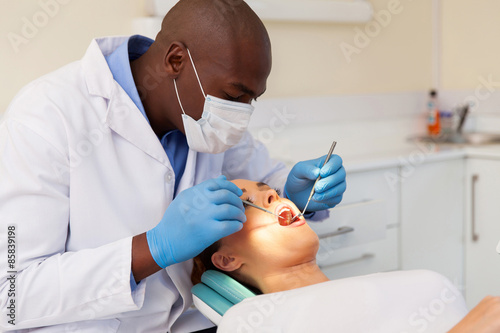 male dentist examining womans teeth
