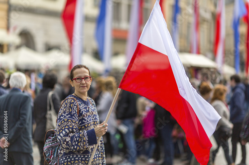 Woman on the street holding a flag of the Republic of Poland.