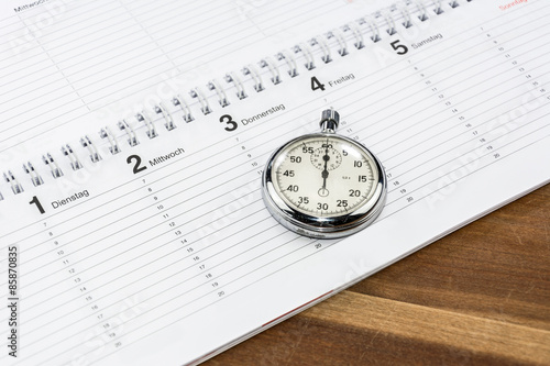 Stoppuhr liegt auf Terminkalender als Symbol für Zeitmanagement oder Terminplanung