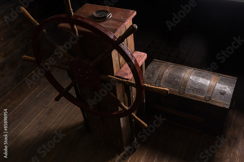 Wooden Chest Next to Steering Helm on Deck of Ship