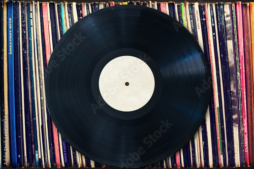 Vinyl record with copy space in front of a collection of albums (dummy titles), vintage process