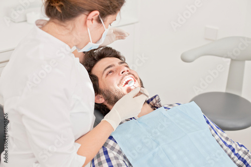 young happy man and woman in a dental examination at dentist