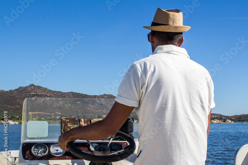 man driving a boat near the coast