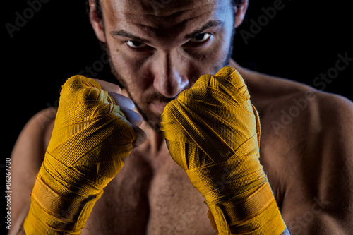 The man in boxing gloves. Young Boxer fighter over black backgro
