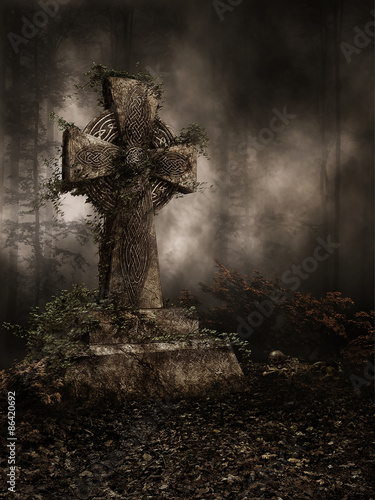 Nagrobek z krzyżem pokryty jesiennym bluszczem w ciemnym lesie