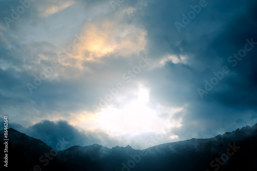 Nature - Mountain scenery with a dramatic sky against the light - computer generated image