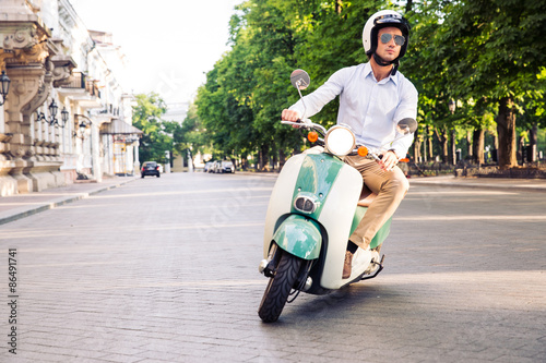 Fashion man driving a scooter