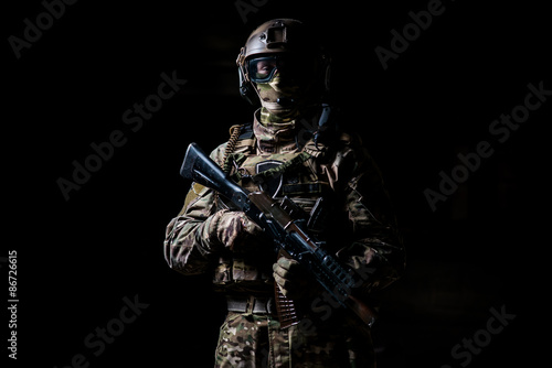 Soldier in camouflage hold machine gun