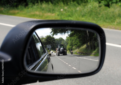 Reflection of tractor in car wing mirror.