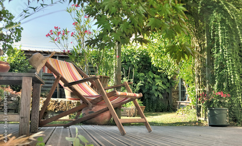 chaise longue dans jardin sur terrasse en bois 
