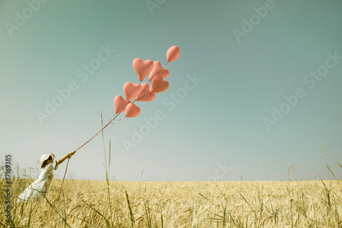 Konzept für Liebe, Freiheit, Mut. Hintergrund mit roten Luftballons und einem Mädchen im Sommer 