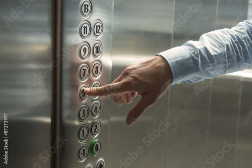 Finger pressing the button in the elevator