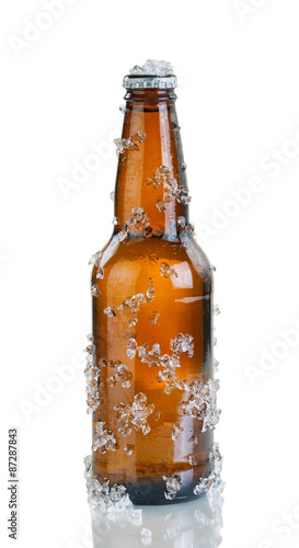 Beer bottle with ice and condensation on white background