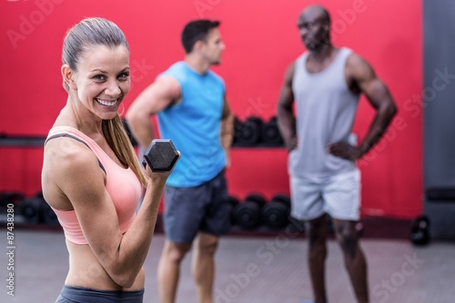 Muscular woman lifting a dumbbell 