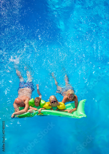 Family Outside Relaxing In Swimming Pool