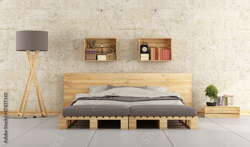 Modern bedroom with pallet bed on brick wall 