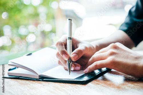 close up of woman writing her journal 