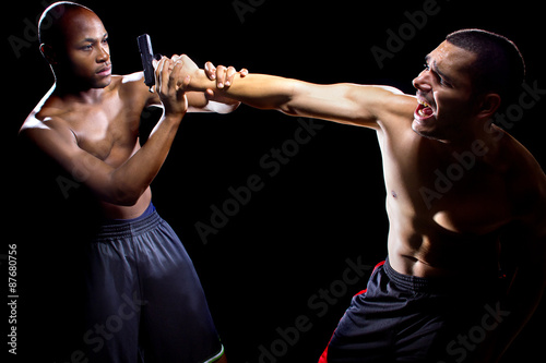 Martial artist disarming a criminal with a gun or close quarter combat