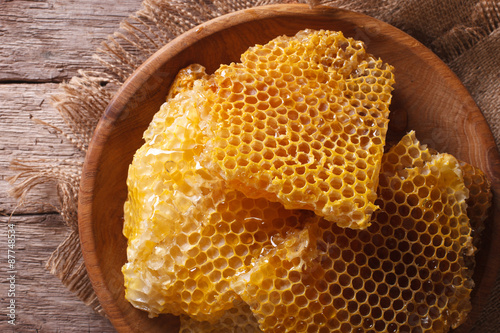 Golden honeycombs on a wooden plate. Horizontal top view closeup 