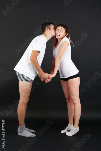 Funny young couple on black background