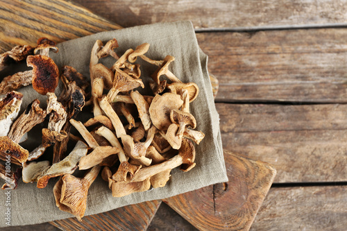 Dried mushrooms with spices on wooden background