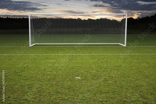 empty amateur football goal posts and nets shot at sunset