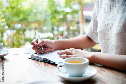 cup of tea with background of woman writing 