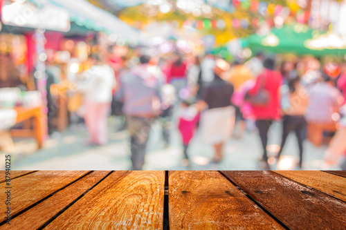 Blurred image of people walking at day market in sunny day, blu