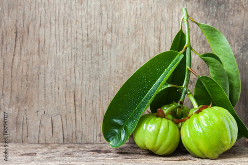 Still life with fresh garcinia cambogia on wooden background 