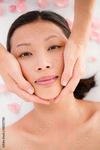 Attractive young woman receiving facial massage 