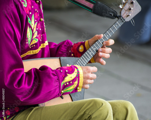 Man playing balalaika on the street. Unrecognizable person.