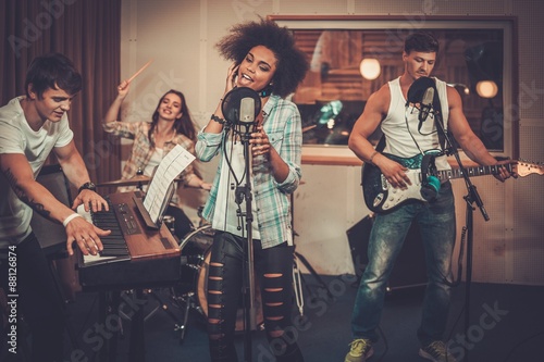 Multiracial music band performing in a recording studio