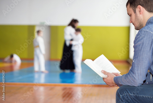 Father waiting for his kids training martial arts