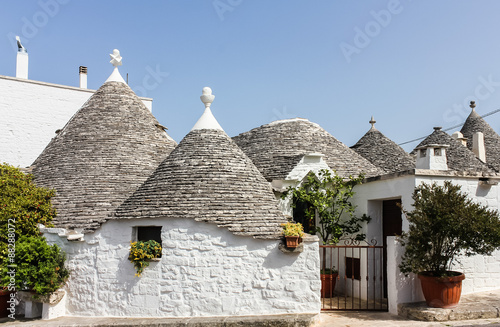 Typical unique white trulli buildings with stone walls and conical roofs in Alberobello, Apulia, Italy