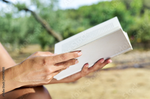 young woman reading a book outdoors