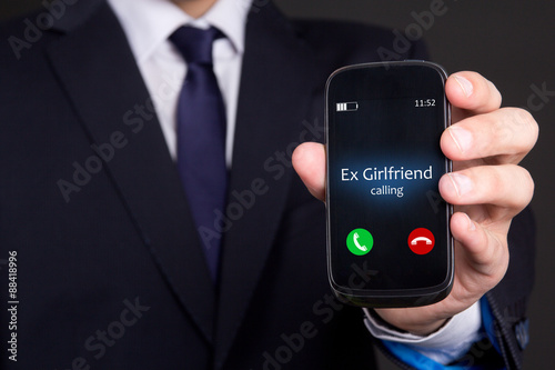male hand holding smart phone with incoming call from his ex gir