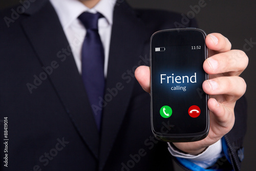 male hand holding smart phone with incoming call from his friend